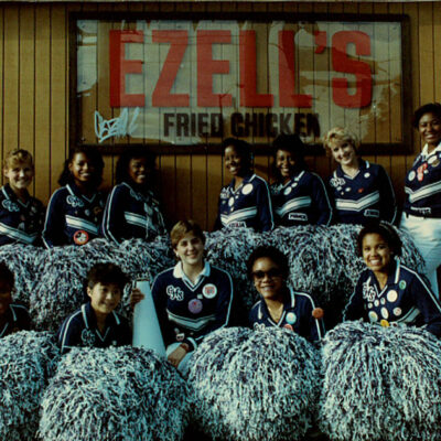 Cheer team in front of Ezell's Famous Chicken sign